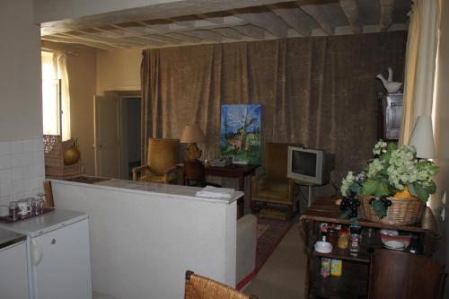 Chevannes快乐农场住宿加早餐酒店的一间带厨房的客厅和一间带电视的客厅。