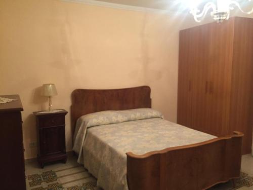 Caltabellottacasa MARINO的一间卧室配有一张带木制床头板和一张桌子的床。