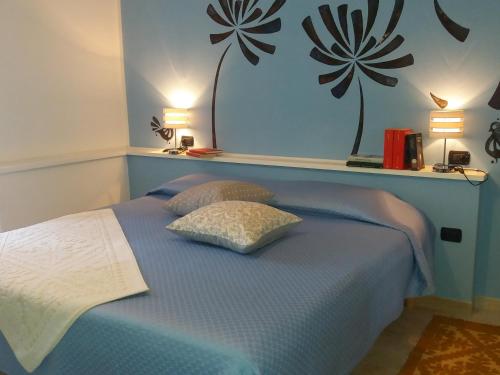 萨萨里I Due Ciuchini Sardinia的一间卧室配有蓝色的床和两个枕头