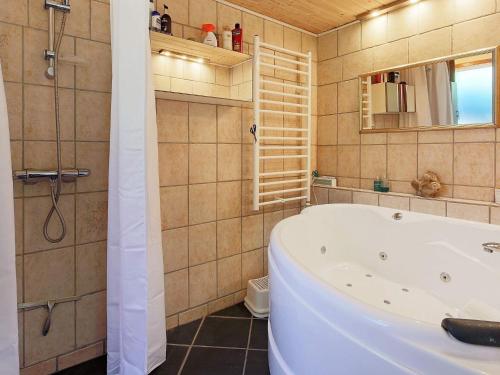 吉利勒杰6 person holiday home in Gilleleje的浴室配有浴缸、淋浴和镜子