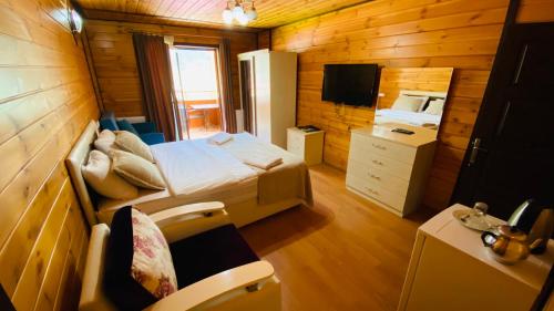 乌宗Kaya Residence的一间卧室配有一张床,并在一间客房内配有电视。