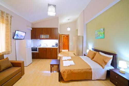 卡图艾塞特斯Villas metoxi的一间卧室配有一张床和一张沙发,还设有一间厨房