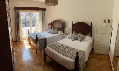 孔迪镇Casa Oliveira的一间卧室设有两张床和窗户。