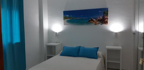 阿尔赫西拉斯Apartamento Junto a El Corte Inglés Algeciras 2的小卧室配有带蓝色枕头的床