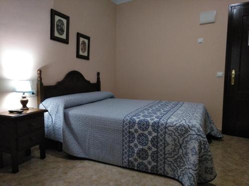 卢塞纳多边形旅馆的一间卧室配有一张床和一张带台灯的桌子