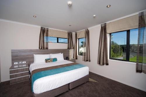 奥克兰Best Western Ellerslie International Hotel的一间卧室设有一张床和一个大窗户