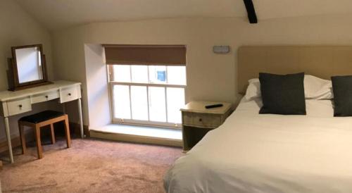 奥克姆Oakham Hotel的一间卧室配有一张床、镜子和窗户
