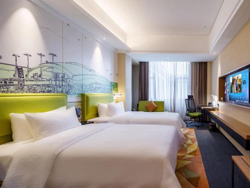 花都广州白云机场北希尔顿欢朋酒店Hampton by Hilton Guangzhou Baiyun Airport North的酒店客房配有两张床和一张书桌