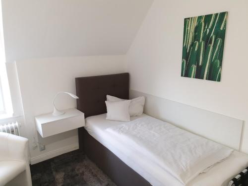 巴特萨尔茨乌夫伦Villa zur schönen Aussicht的小卧室配有白色的床铺和绿色的绘画