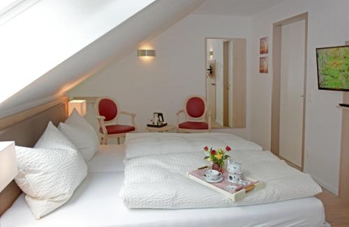 HellwegeDer Eichenhof的一间卧室,配有一张带鲜花托盘的床