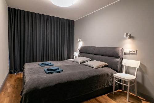 文茨皮尔斯Brand New, Family-friendly with a great location - Moon Apartment的一间卧室配有一张大床和一把椅子