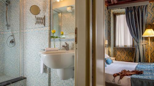 罗马Residenza Canova Tadolini - Guesthouse的一间带水槽和淋浴的浴室以及一张床