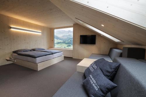 阿德尔博登Revier Mountain Lodge Adelboden的客房设有两张床、一台电视和一张沙发。