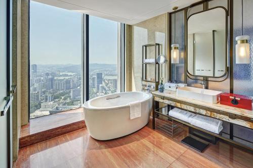 惠州惠州佳兆业铂尔曼酒店的带浴缸的浴室和大窗户
