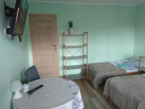 露米雅Pokoje Gościnne Bajka的客房设有两张床、一张桌子和一张书桌。