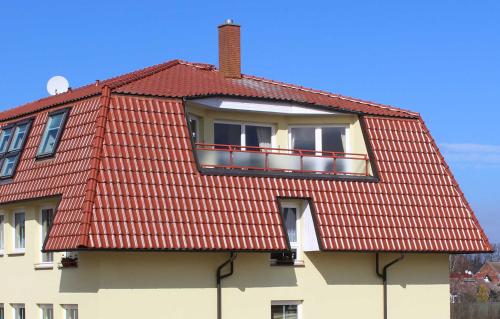 乌埃克尔明德Ferienwohnung am Schloss的带阳台的红色屋顶