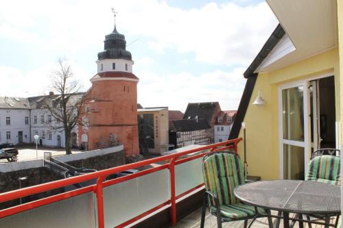 乌埃克尔明德Ferienwohnung am Schloss的阳台配有桌椅和灯塔。