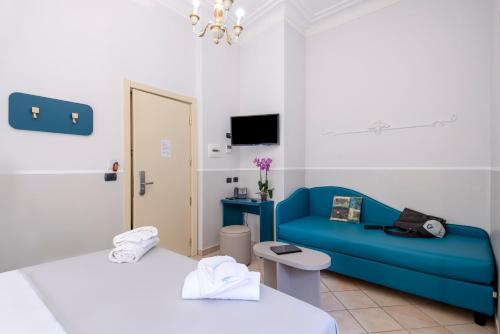 罗马德里佛酒店的一间设有两张床和蓝色沙发的房间