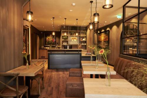 乌得勒支City Center Lodge Utrecht的一间带2张桌子的餐厅和一间酒吧