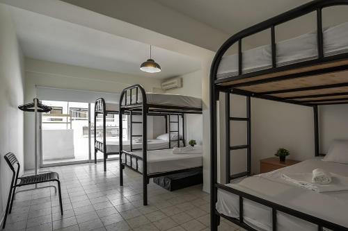 利马索尔White Hostel的带三张双层床和一间浴室的客房