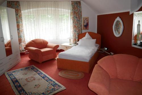 巴特基辛根沃夫莎索尼亚酒店的一间卧室配有一张床、一把椅子和一张沙发