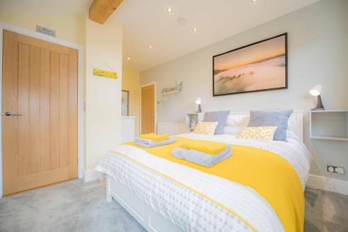 兰戈伦Nesscliffe的一间卧室配有一张大床,提供黄色和蓝色的枕头