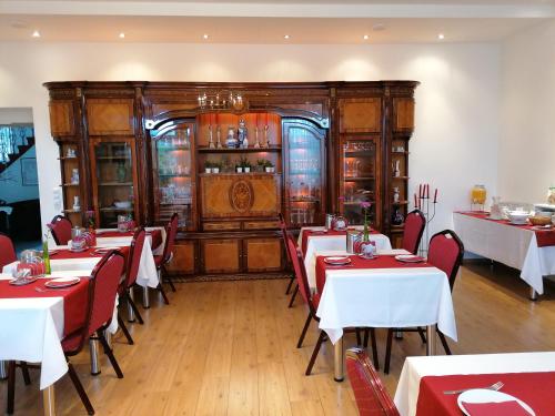 丰斯多夫卡尔奥古斯特住宿加早餐旅馆的餐厅设有红色和白色的桌椅
