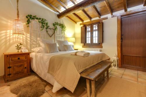 巴尔韦尔德德尔夫雷斯诺Casa Rural A Cashiña da Lagarteira的一间卧室设有一张大床和一张木凳