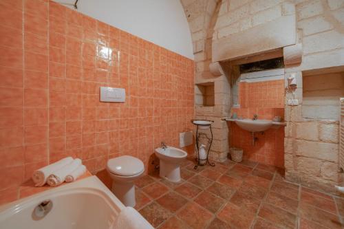 博尔加涅Agriturismo Masseria del Bosco Makyva的带浴缸、卫生间和盥洗盆的浴室