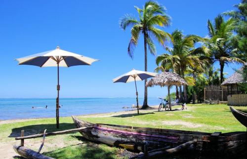 Foulpointe乐拉冈酒店的棕榈树和遮阳伞的海滩和海洋