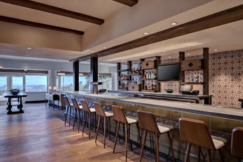 圣克鲁兹查米纳德度假酒店&Spa的餐厅内的酒吧配有椅子和柜台