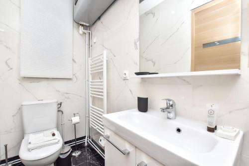 巴黎CMG Philharmonie de Paris/ Jaures的白色的浴室设有卫生间和水槽。