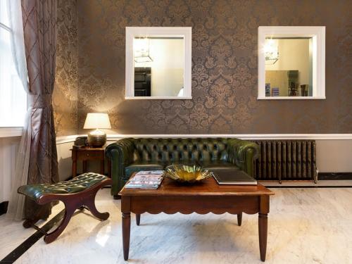 伦敦斯汤顿住宿加早餐酒店的客厅配有绿色沙发和桌子