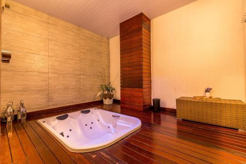 卡埃特卡埃特陶亚会议酒店的铺有木地板的客房内设有浴缸。