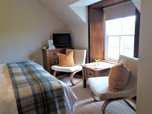 斯特兰拉尔Corsewall Arms Guest House的一间卧室配有一张床、两把椅子和一个窗户