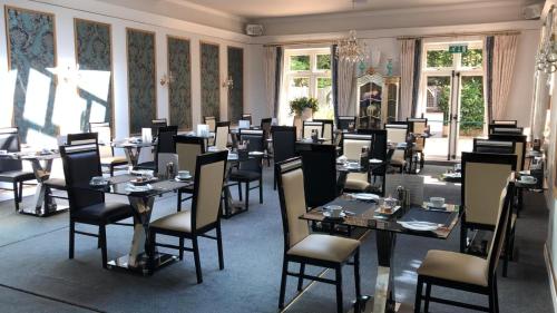 伯恩茅斯朗特里庄园酒店的用餐室设有桌椅和窗户。