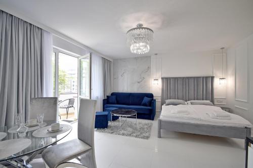 科沃布热格CRYSTAL Apartament 80m od plaży的一间卧室配有一张床和一张蓝色的沙发