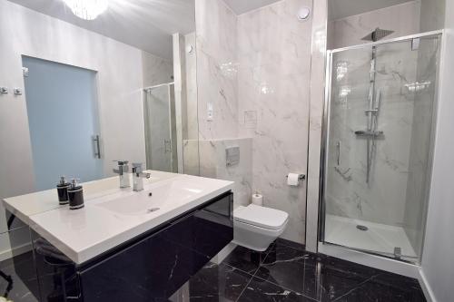 科沃布热格CRYSTAL Apartament 80m od plaży的一间带水槽、淋浴和卫生间的浴室