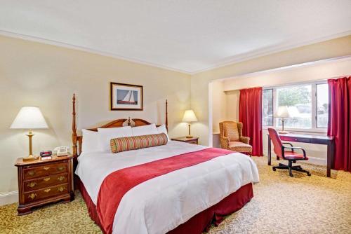 锡康克锡康克/普罗维登斯区华美达酒店的酒店客房设有一张大床和一张书桌。