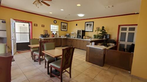 McCameyLa Bonita Inn & Suites - McCamey的一间带桌椅的餐厅和一间厨房