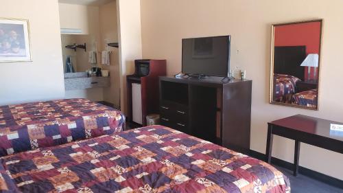 McCameyLa Bonita Inn & Suites - McCamey的酒店客房设有两张床和一台平面电视。