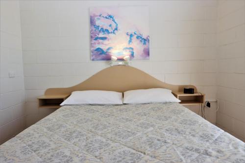 Burrill Lake湖边公寓的一间卧室配有一张带床头板的床