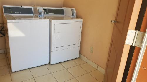 McCameyLa Bonita Inn & Suites - McCamey的一台洗衣机和烘干机的顶部有两个微波炉