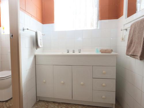 Burrill Lake湖边公寓的浴室配有白色水槽和卫生间。
