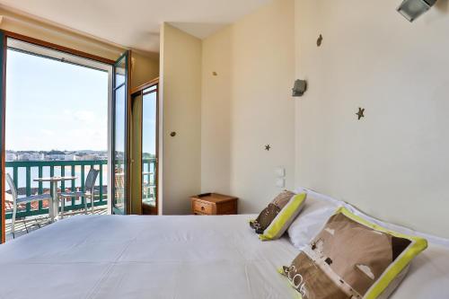 西布勒Hotel Agur Deneri的一间带大床的卧室和一个阳台