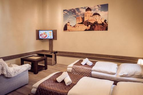 波普拉德Hotel Kaskada的一间酒店客房,设有两张床和电视