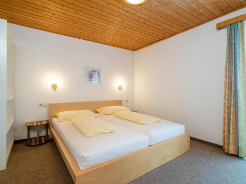 弗拉绍Appartements Maurer的一间卧室配有白色床单和木制天花板。
