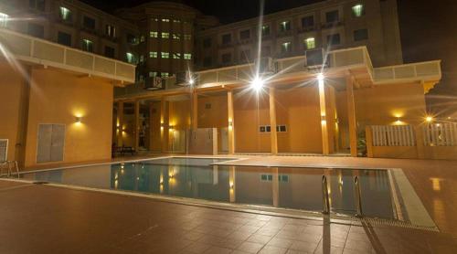 拉瓦斯马来西亚老越塞里酒店的一座空的游泳池,晚上在建筑物里