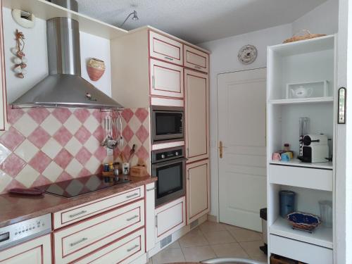 马赛Appartement Marseille Vacances的厨房配有白色橱柜和炉灶烤箱。
