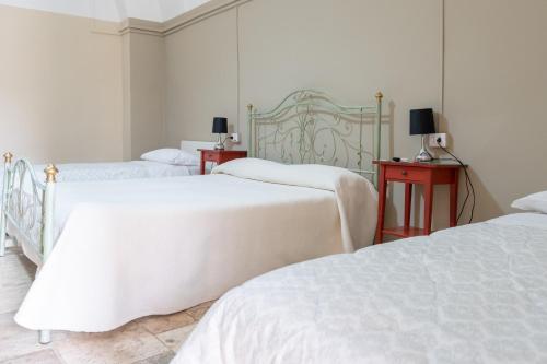 比通托B&B Santi Medici的一间卧室设有两张床和两张带台灯的桌子。